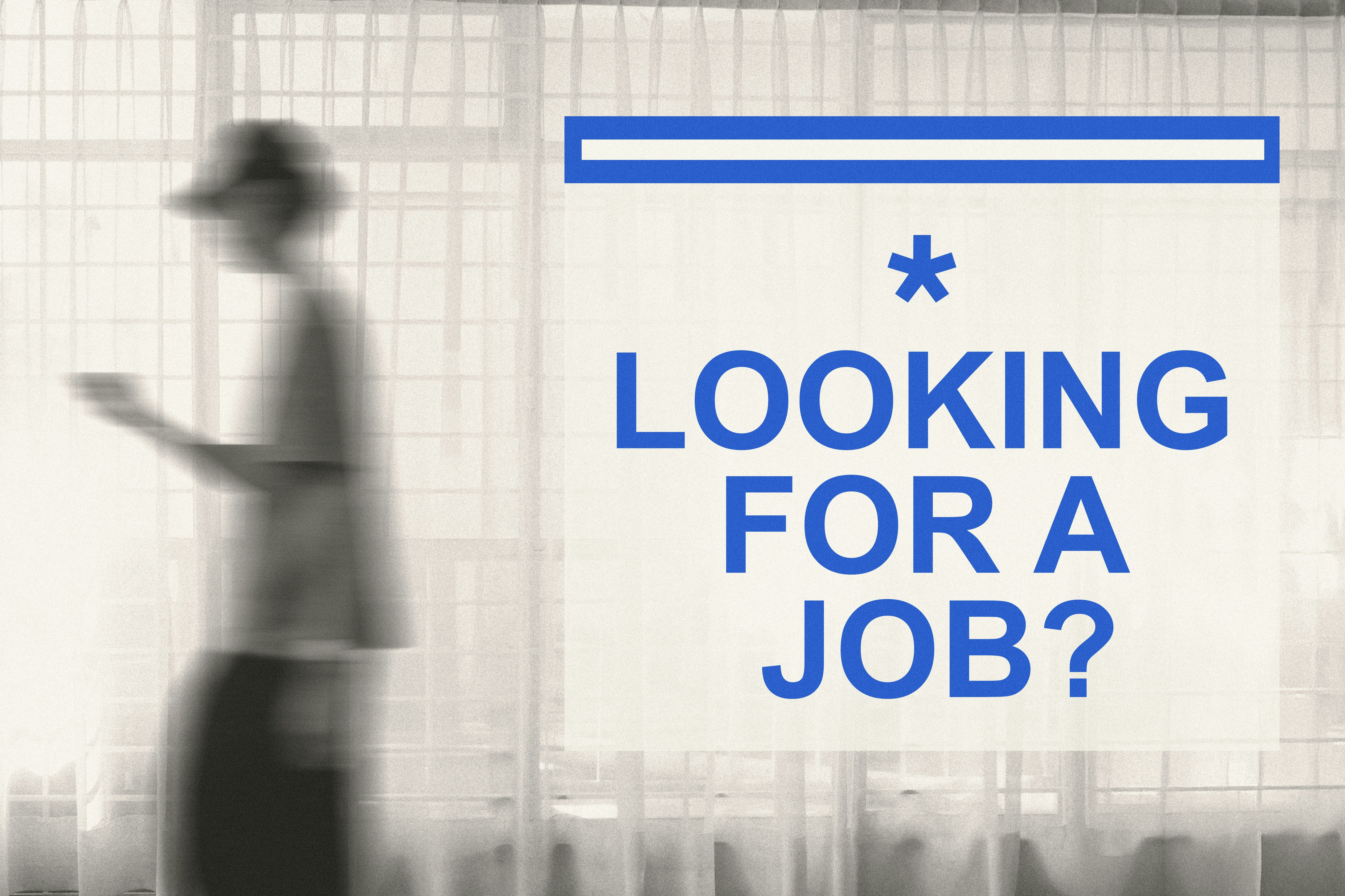Blurred figure walking past a sign that reads 'Looking for a job?'