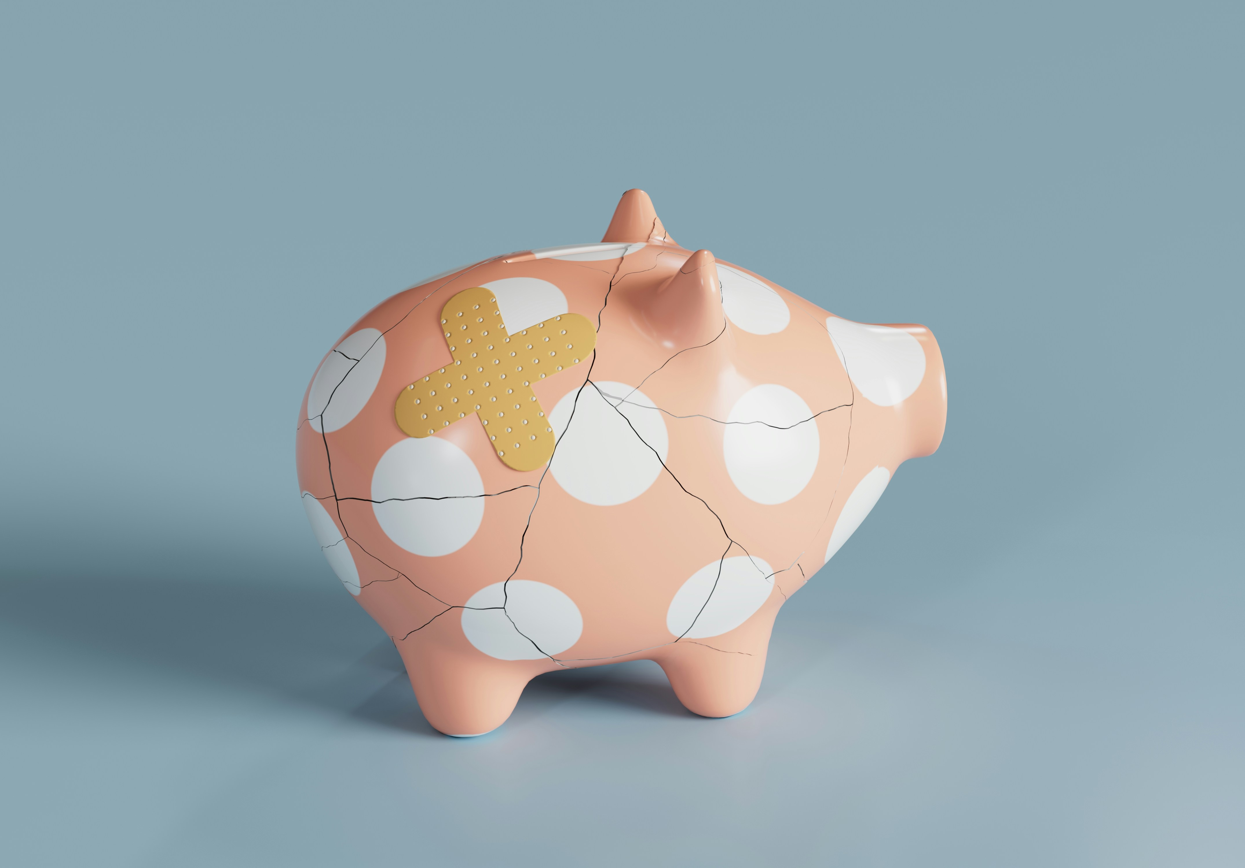 Cracked piggy bank with a bandage on it against a blue background