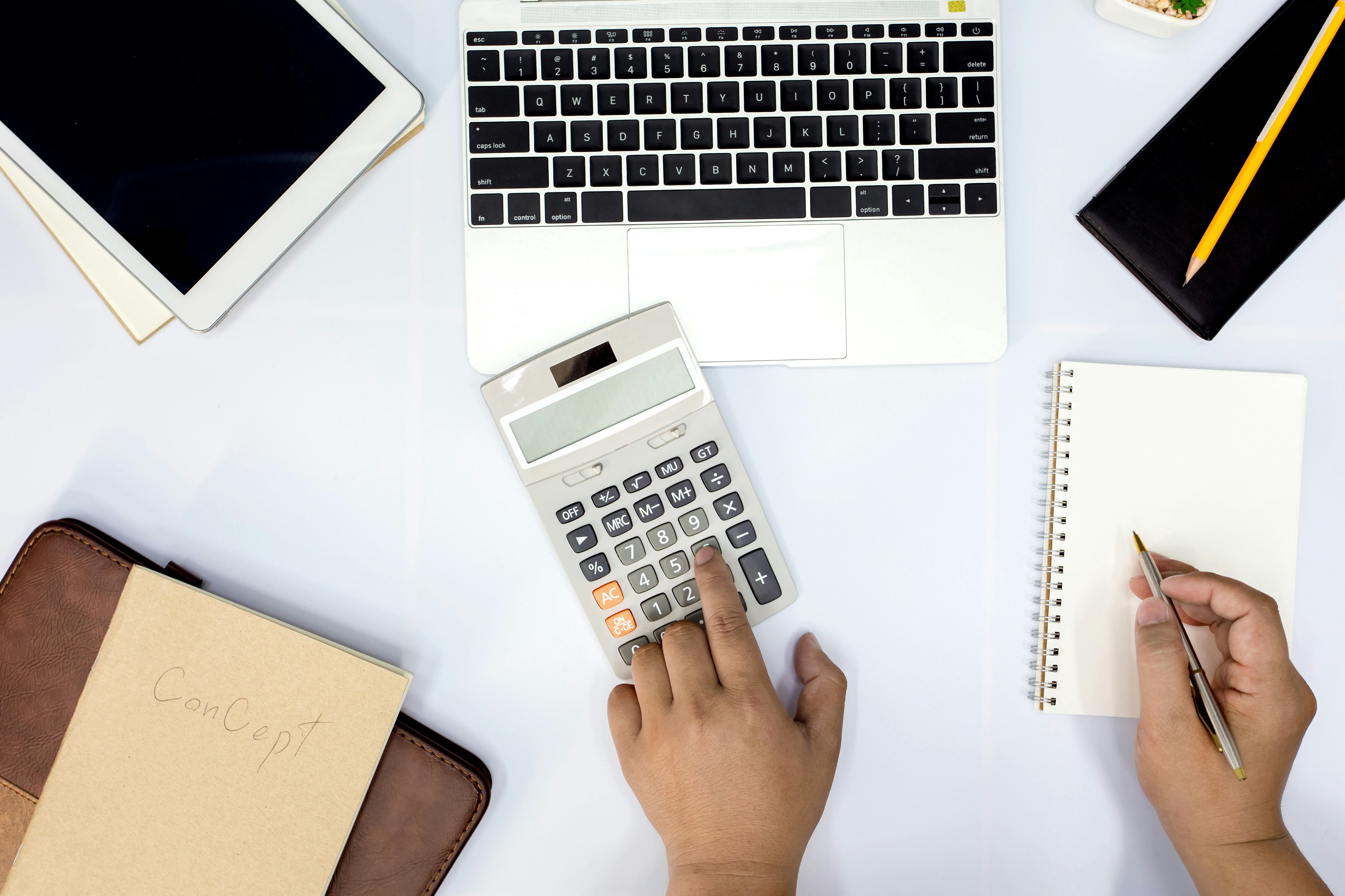 Calculator and laptop on desk for billing and financial management